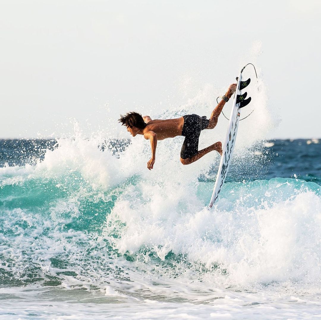 A man performing tricks on a surf board. 